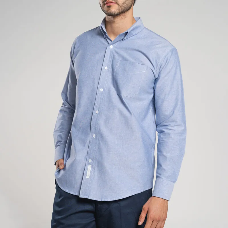 Hombre luciendo una camisas oxford azul, un básico versátil que combina confort y un look pulcro para cualquier ocasión.