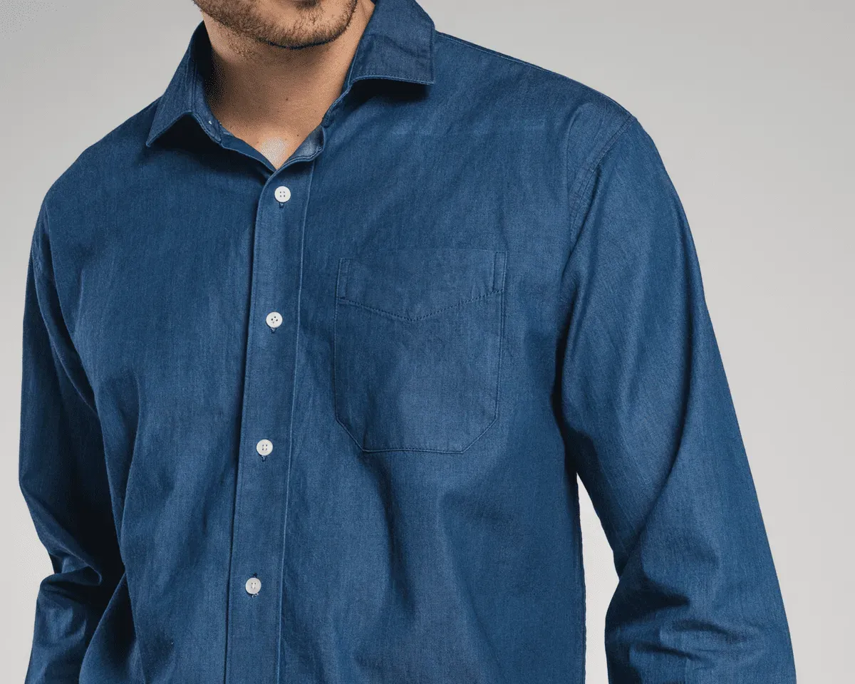 Imagen de un joven modelando la camisa de mezclilla de los uniformes corporativos de Airman