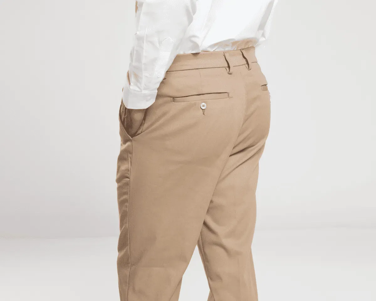 Foto de un hombre modelando pantalones beige de los uniformes corporativos de Airman